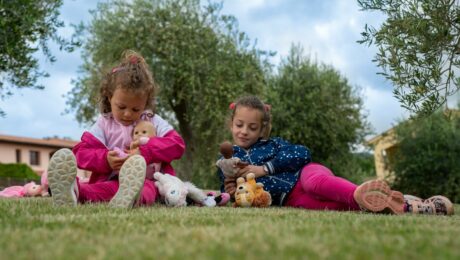 Due bambine che giocano in un prato verde, Borgo Etrusco è il luogo ideale per tutti per una vacanza rilassante.