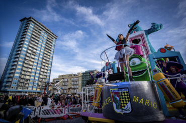 Carnevale di Follonica, carro allegorico che passa sotto la torre azzurra simbolo di Follonica
